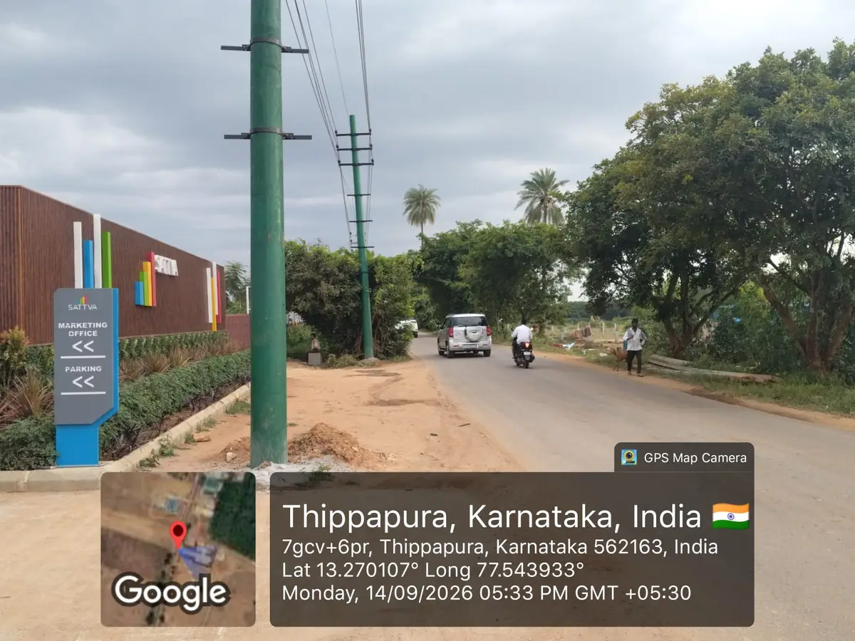 Sattva Ekatra Site Progress 14 September 2026 - approach road to the project site with Sattva marketing office and parking signage, GPS-stamped Thippapura, Doddaballapura