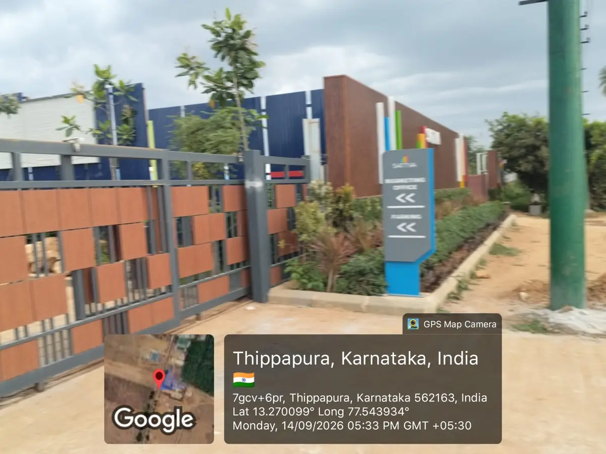 Sattva Ekatra Site Progress 14 September 2026 - site entrance gate with Sattva wayfinding sign for marketing office and parking, GPS-stamped Thippapura, Doddaballapura