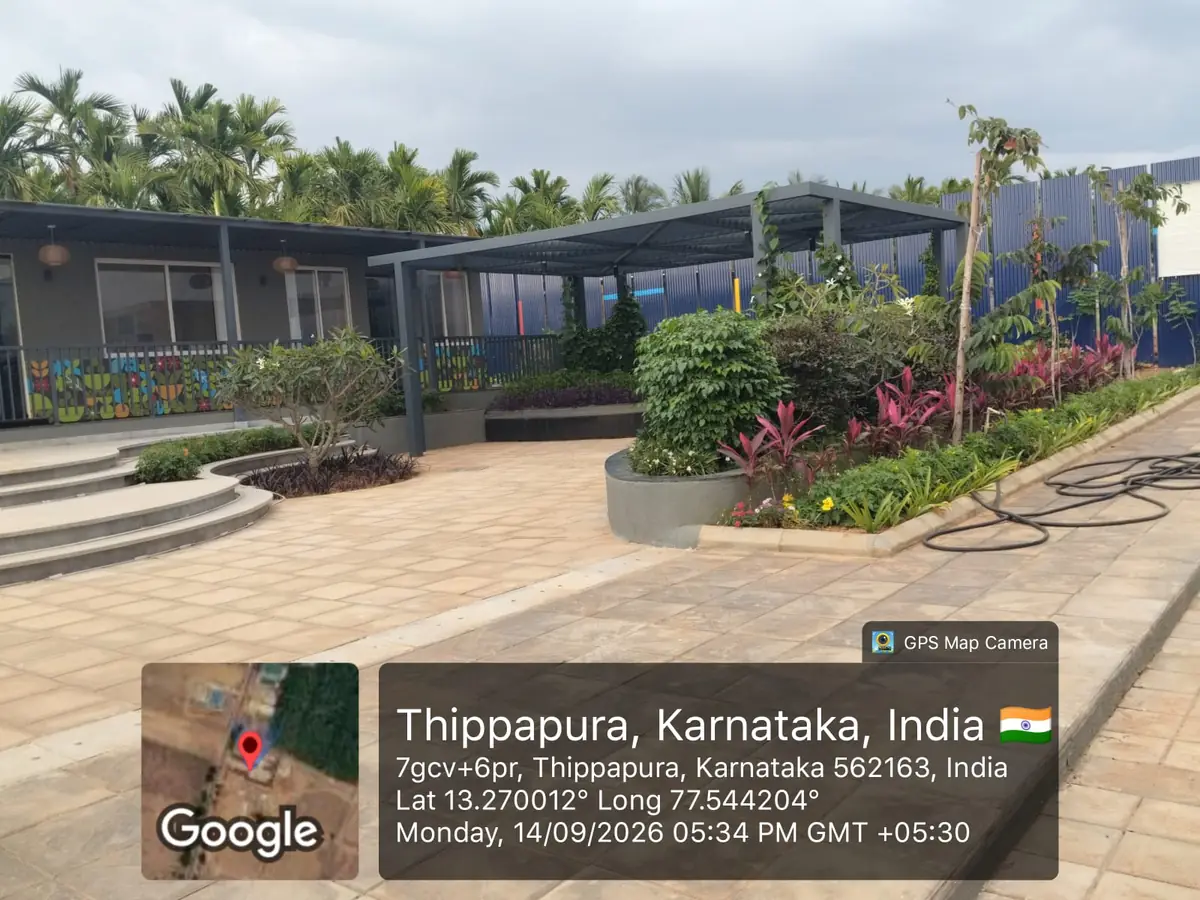 Sattva Ekatra Site Progress 14 September 2026 - landscaped garden, pergola and paved walkway beside the marketing office, GPS-stamped Thippapura, Doddaballapura